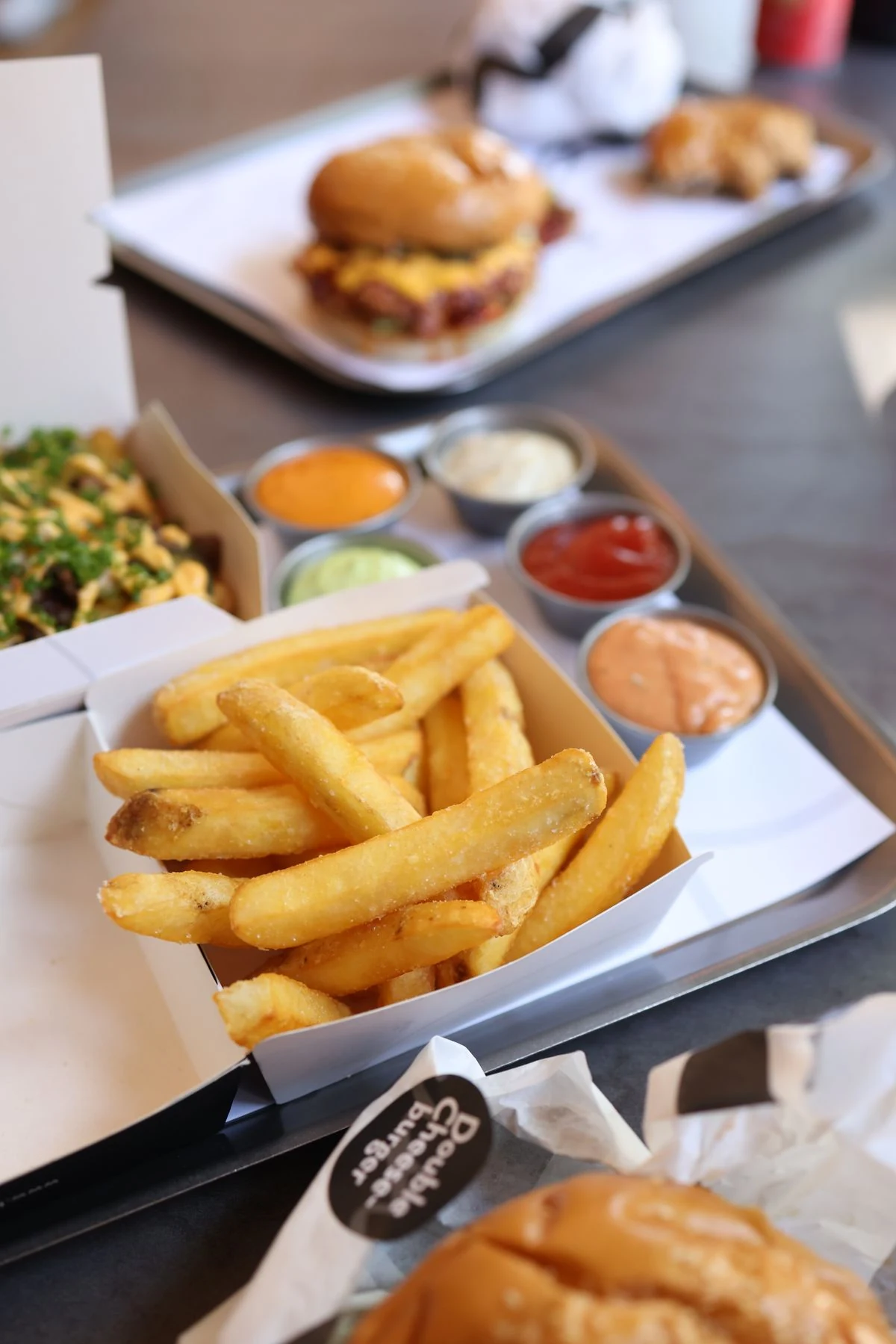 A spread of burgers, fries and sauces